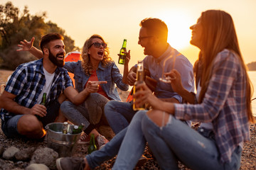 Happy young friends having picnic on the beach