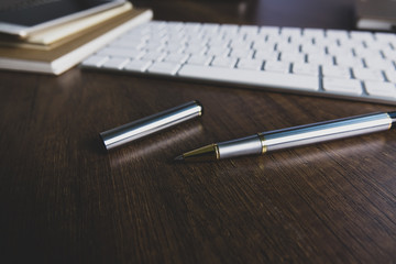 Office desk table with notebook, computer keyboard, mobile phone and other office supplies. Top view with copy space, flat lay. vintage background.