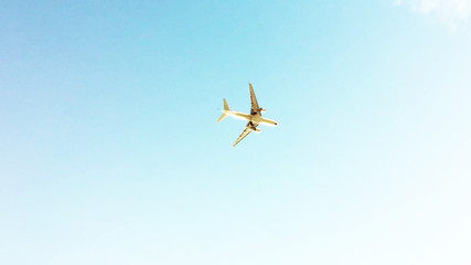 airplane in the blue clear sky, view from below of flying aeroplane. low angle shot background with copy space.