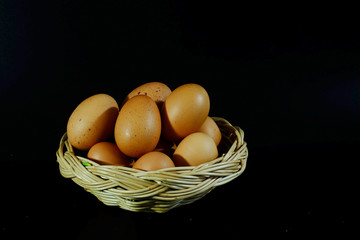 Eggs in wood basket and have space for write wording on black background, popular useful high protein food for making many kinds of food, suitable for children and growth age people, easy to cook