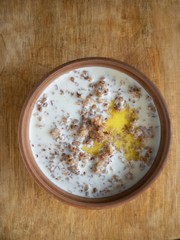 Bowl of cooked buckwheat with milk and run butter - top view
