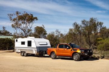 Off road pickup car with air intakes and a white caravan trailer in Western Australia - obrazy, fototapety, plakaty