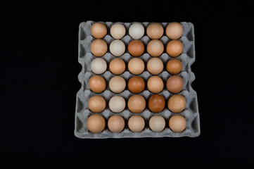 Thirty chicken eggs in a carton box, isolated on black mat background