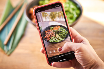 Woman taking photo poke bowl