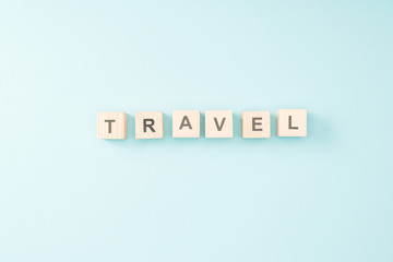 top view of wooden cubes with travel lettering on blue background