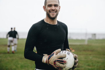 Close up of a smiling soccer player standing on field © Jacob Lund