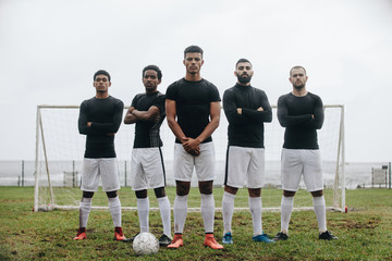 Football players standing on a soccer field in front of goalpost © Jacob Lund