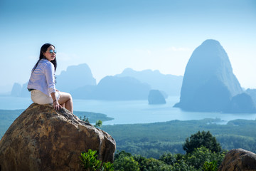 Fototapeta na wymiar Young woman sitting on a mountain top