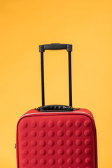 red travel bag with handle isolated on yellow