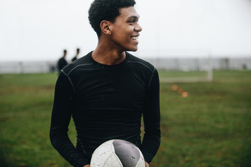Portrait of a footballer standing on field holding a ball © Jacob Lund