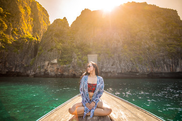 Young asian woman relax on long tail boat at Maya bay
