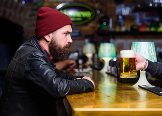 Man with beard spend leisure in dark bar. Brutal lonely hipster. Hipster relaxing at bar. Brutal hipster bearded man sit at bar counter. Friday evening. Bar is relaxing place to have drink and relax