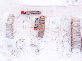 Loader tractor packs logs wood harvesting, Sawmill. Top view aerial.