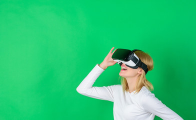 Confident young woman adjusting her virtual reality headset and smiling. Woman using virtual...