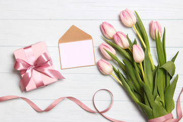 beautiful tulips bouquet, gift and card for text on wooden background top view. Mother's Day Background, International Women's Day, Birthday. Holiday, give a gift.