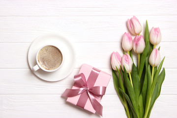 bouquet of beautiful tulips, gift and coffee on wooden background top view. Mother's Day Background, International Women's Day, Birthday. Holiday, give a gift.