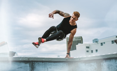 Athletic man doing fitness training on rooftop