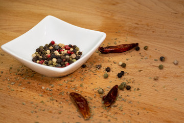Peppercorns laying in white porcelain container