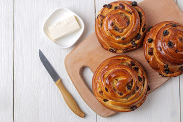Tasty buns with butter on a white wooden background. fresh bakery. breakfast. view from above