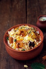 Prawn or Shrimp biryani in a clay poton wooden background, selective focus