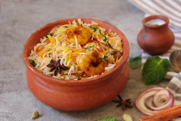 Prawn or Shrimp biryani in a clay poton wooden background, selective focus