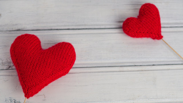 two red knitted hearts on wooden background . the concept of Valentine's day