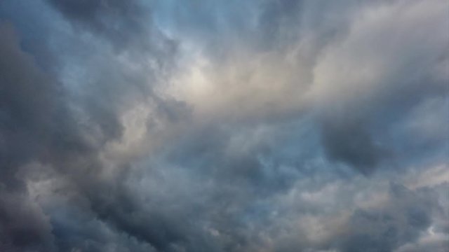 Time lapse of overcast stormy ghostly cloudy sky with layers of nimbostratus and cirrus clouds in backlit with wonderful lights