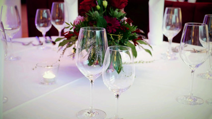 wine glasses on a decorated wedding table with bouquet flowers, wedding reception concept background.