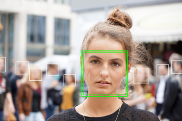 young woman picked out by face detection or facial recognition software - several other faces...