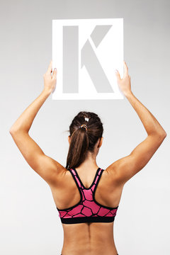 fit girl holding the letter k