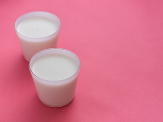 Healthy breakfast. Yogurt in white glasses on pink background. Copy space