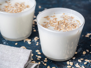 Healthy breakfast. Yogurt with oat flakes in white glasses on a blue background.