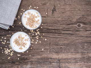 Healthy breakfast. Yogurt with oat flakes in white glasses on a wooden table