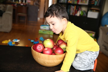 little boy of three years with a basket of apples