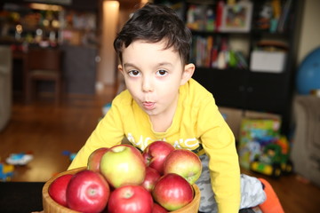 Fototapeta premium little boy of three years with a basket of apples