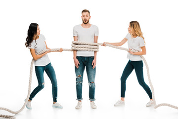 Obraz premium young women holding rope around scared young man isolated on white