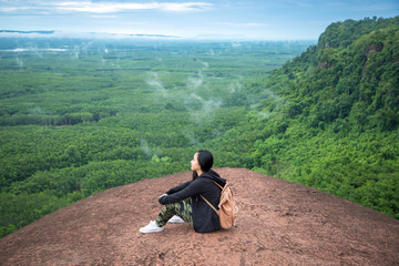 Naklejka na ściany i meble Young woman sitting on a mountain top