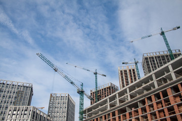 Fototapeta na wymiar High-rise multi-storey buildings under construction. Tower cranes near building. Activity, architecture, development process, skyscraper