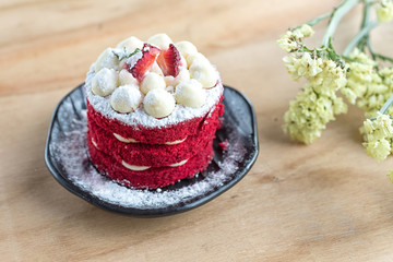 Thai Cake. Velvet red cake. Cookies decorated with red cake on wooden table and flower. strawberries morning. Delicious cake. Cake with icing sugar. Selective Focus.