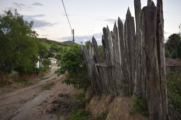 Estrada de terra em paisagem rural e cerca de madeira