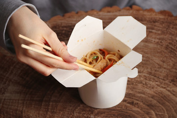 man eating noodles using chopstiks