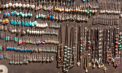 Necklaces and tendrils hanging on a brown wall
