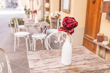 Artificial flower in vase as decoration in outdoor retro cafe in Italy