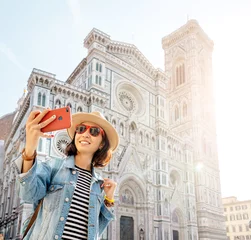 Fotobehang Happy asian woman taking selfie with her smartphone in the background of the Santa Maria Del Fiore Cathedral in Florence © EdNurg