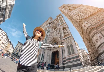Fotobehang Happy asian woman tourist with raised hands at the old town square of Florence near Santa Maria Del Fiore Cathedral. Travel in Italy concept © EdNurg