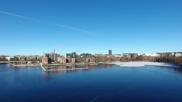 Aerial view over a lake towards city skyline in winter