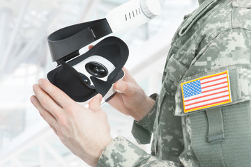 Indoors shot of American soldier holding VR glasses