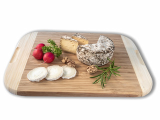Cheese from France named Tommette des Alpes and white round goat cheese with nuts and radish and parsley on the white background with shadow
