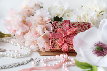red box with a gift, hydrangea and Magnolia flowers, necklace, earrings, pearls,