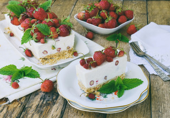 Cheesecake with berries, strawberries on shortbread dough. Delicious and simple cake on wooden background. Cheese pie. Homemade baking. Copy space.